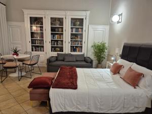 ein Schlafzimmer mit einem großen Bett und ein Wohnzimmer in der Unterkunft CENTRO STORICO HOME with terrace in Catania