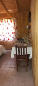 ein Tisch und ein Stuhl in einem Zimmer mit Fenster in der Unterkunft Complejo Del Bosque in El Bolsón