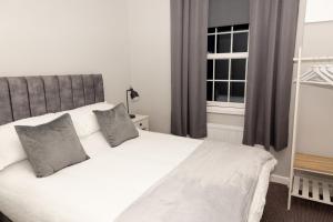 een slaapkamer met een wit bed en een raam bij The Terminus Loft in Conisbrough