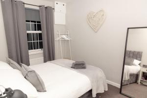 een slaapkamer met twee bedden en een spiegel bij The Terminus Loft in Conisbrough +10 foto's