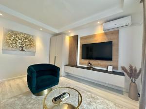 sala de estar con TV y silla verde en Aurora Premium Cosmopolis, en Tunarii