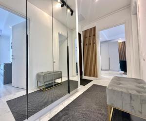 Habitación con pared de cristal con banco y taburete en Aurora Premium Cosmopolis, en Tunarii