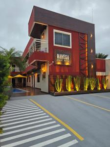 un edificio rojo con un letrero al lado de una calle en Navega Hotéis, en Navegantes