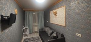 a living room with a couch and a painting on the wall at Центр 2окремі кімнати балкон in Ivano-Frankivsʼk