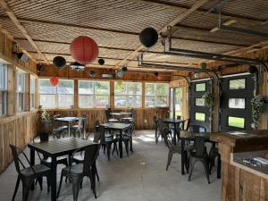a dining room with tables and chairs and windows at Auberge MicKy Inc in Edmundston