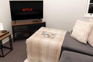 een woonkamer met een bank en een tv bij The Terminus Loft in Conisbrough