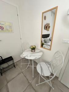 - une table et des chaises dans une pièce avec un miroir dans l'établissement Affittacamere LA CASA DI GIADA a 5 minuti dal centro di Imola - parcheggio privato interno per furgoni e auto, à Imola