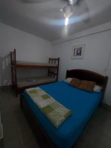 una camera con letto blu e panca di Pousada Formosa a Porto Seguro Altre 114 foto