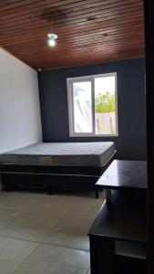 a bedroom with a bed in a room with a window at Casa com piscina e pátio grande in Capão da Canoa