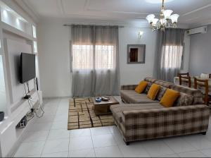 a living room with a couch and a tv at Le nid douillet in Yaoundé