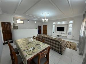 a living room with a table and a television at Le nid douillet in Yaoundé