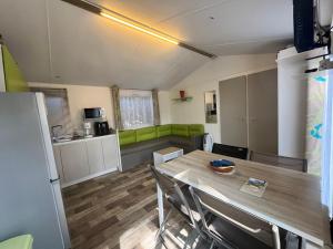 - un salon avec une table et un canapé vert dans l'établissement Mobile Home Camping Paradis, à Trédrez