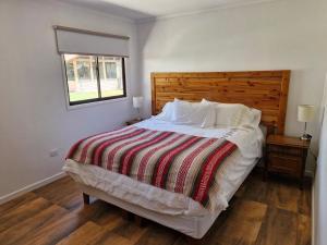 una camera da letto con un letto grande con testiera in legno di Oasis y canto de pájaros Piedra Colgada Copiapó a Copiapó Altre 50 foto