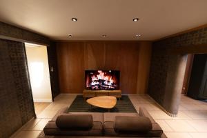 un salon avec un canapé et une cheminée dans l'établissement Les pantoufles dans les étoiles, à Eppeldorf