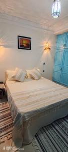 ein Schlafzimmer mit einem großen Bett und einer blauen Tür in der Unterkunft Dar Andalous in Annaba