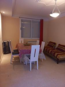ein Wohnzimmer mit Tisch, Stühlen und Sofa in der Unterkunft Dar Andalous in Annaba