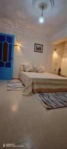 ein Schlafzimmer mit einem Bett mit blauer Tür in der Unterkunft Dar Andalous in Annaba