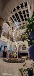 eine große Lobby mit einem Kronleuchter in einem Gebäude in der Unterkunft Dar Andalous in Annaba + 5 Fotos
