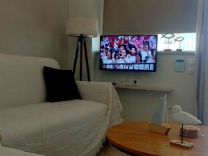 a living room with a couch and a flat screen tv at Galazio suites 2 Seaside in Salamina
