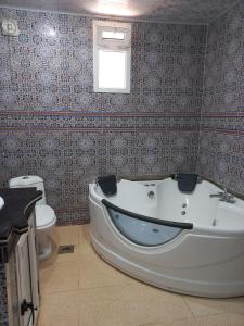 ein Badezimmer mit Badewanne und Toilette in der Unterkunft Dar Andalous in Annaba