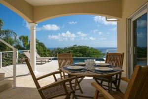 a table on a patio with a view of the ocean at Maria Bluff Cottage Villa-Romantic Ocean Views Modern Private Pool in Contant