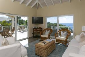 a living room with white furniture and a balcony at Maria Bluff Cottage Villa-Romantic Ocean Views Modern Private Pool in Contant