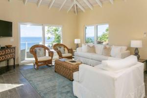 a living room with a white couch and chairs at Maria Bluff Cottage Villa-Romantic Ocean Views Modern Private Pool in Contant