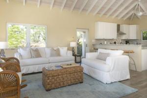 a living room with two white couches and a table at Maria Bluff Cottage Villa-Romantic Ocean Views Modern Private Pool in Contant