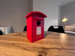 ein rotes Vogelhaus steht auf einem Holztisch in der Unterkunft The Bluebird B&B III in Central Station