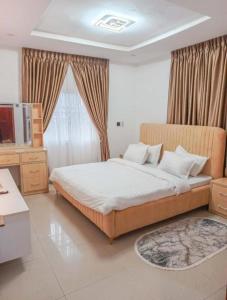 a bedroom with a large bed and a window at Epic Apartment in Abuja