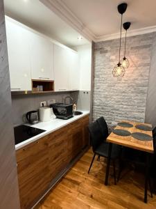 Una cocina con gabinetes blancos y una mesa de madera. en Diamond grey Titova Vila, en Zlatibor