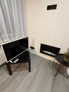 sala de estar con TV de pantalla plana y chimenea en Boris Heven Relax, en Daugavpils 3 fotos más