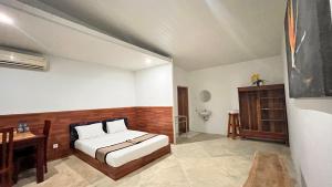 Un dormitorio con una cama y un escritorio. en MenTari GuestHouse, en Gili Gede