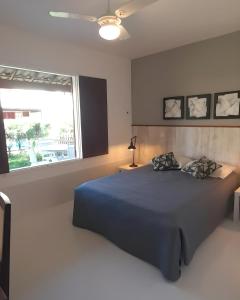um quarto com uma cama azul e uma janela em Linda casa para temporada no Peró/Cabo Frio em Cabo Frio