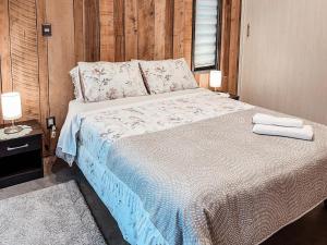 a bedroom with a bed with two towels on it at apartamento campestre con terraza in Puerto Varas +9 photos