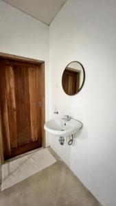 Un baño con un lavabo y un espejo en la pared. en MenTari GuestHouse, en Gili Gede 23 fotos más