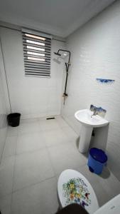un baño con inodoro y lavabo en Prof's Villa, en Kumasi 4 fotos más
