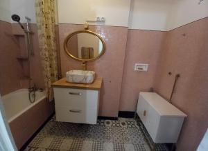 ein Badezimmer mit Waschbecken, Badewanne und Spiegel in der Unterkunft Villa Horizon in Champs-Sur-Marne