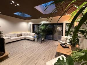 High Tree - Macclesfield - Near AZ, Rail & Peaks في ماكليسفيلد: غرفة معيشة مع الأرائك البيضاء والنباتات الفخارية