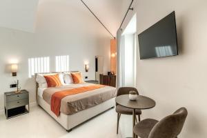 a bedroom with a bed and a tv and a table at Residenze Piazza Dante in Naples