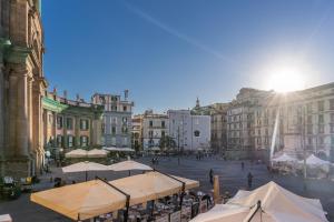 a city square with tables and umbrellas and buildings at Residenze Piazza Dante in Naples