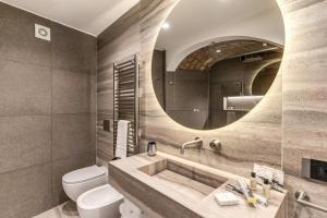 a bathroom with a sink and a toilet and a mirror at Residenze Piazza Dante in Naples +112 photos