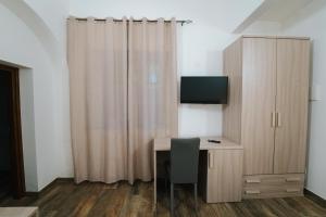 a room with a desk with a television and a curtain at Agriturismo Marzilio in Ficarra +32 photos