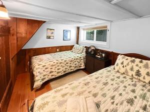 ein Schlafzimmer mit zwei Betten und einem Fenster in der Unterkunft Pond View Cabin in Chittenden