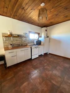 巴沙马拉尔Cabaña chapadmalal Nuestro rancho的厨房配有白色橱柜和冰箱。