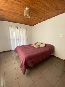 巴沙马拉尔Cabaña chapadmalal Nuestro rancho的卧室里有一张大床，上面铺着红毯子