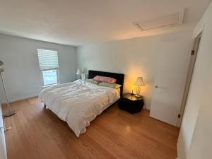 ein Schlafzimmer mit einem Bett und einer Lampe auf einem Holzboden in der Unterkunft your family home in Aurora