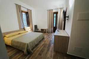 a bedroom with a bed and a flat screen tv at Agriturismo Marzilio in Ficarra