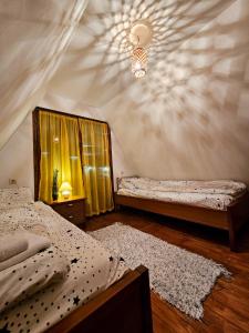 una camera da letto con due letti e un lampadario di Vila Sreća - Kolašin a Kolašin