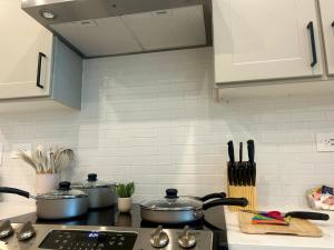cocina con ollas y sartenes en una estufa en A plus location pool washer dryer gym modern, en Sherman